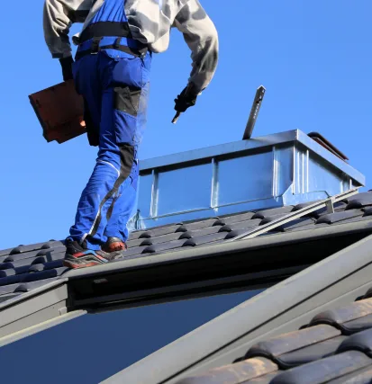 Dachdecker bei präzisen Arbeiten am Ziegeldach